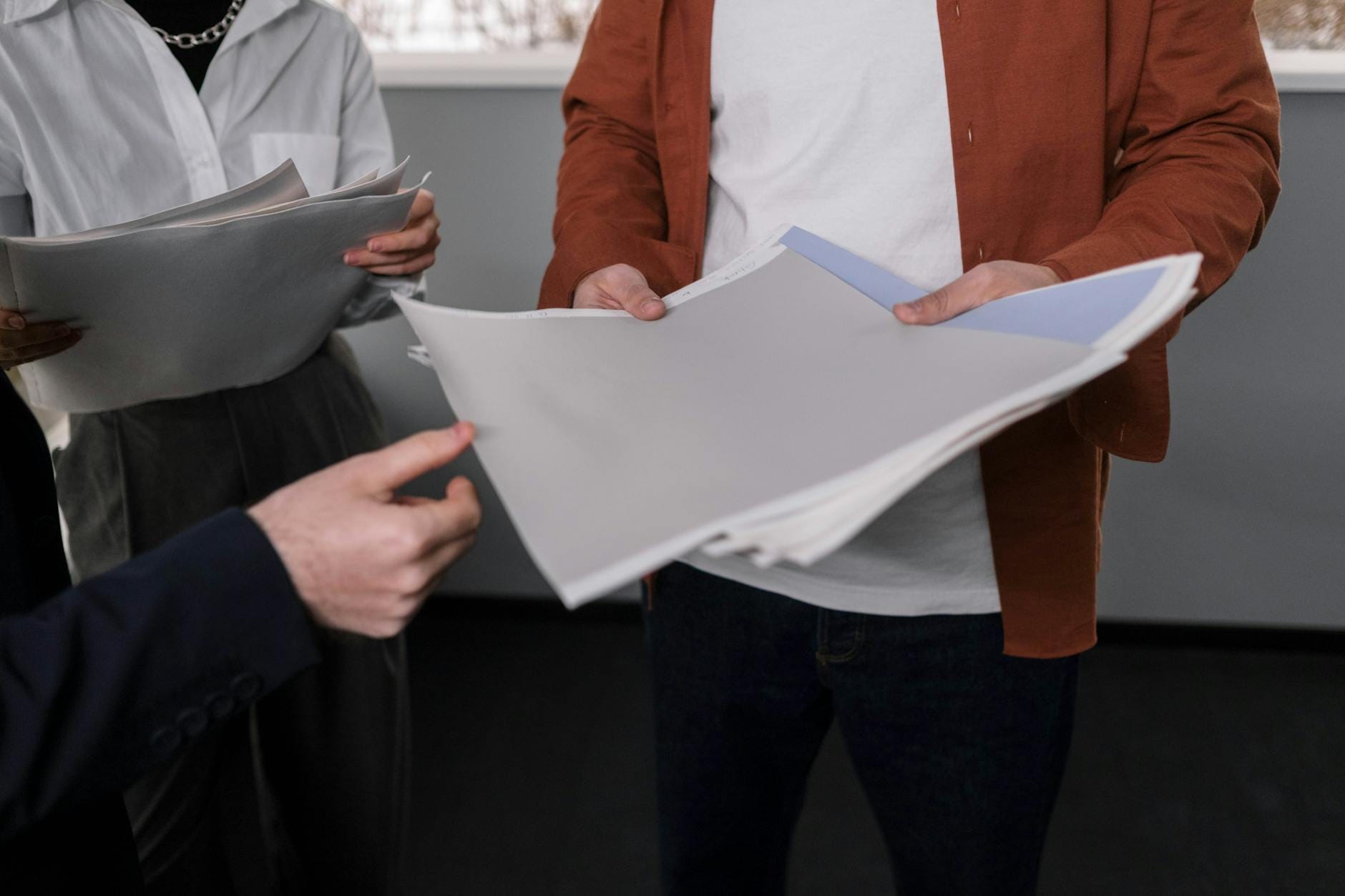 Zespół biurowy omawia próbki materiałów podczas spotkania projektowego