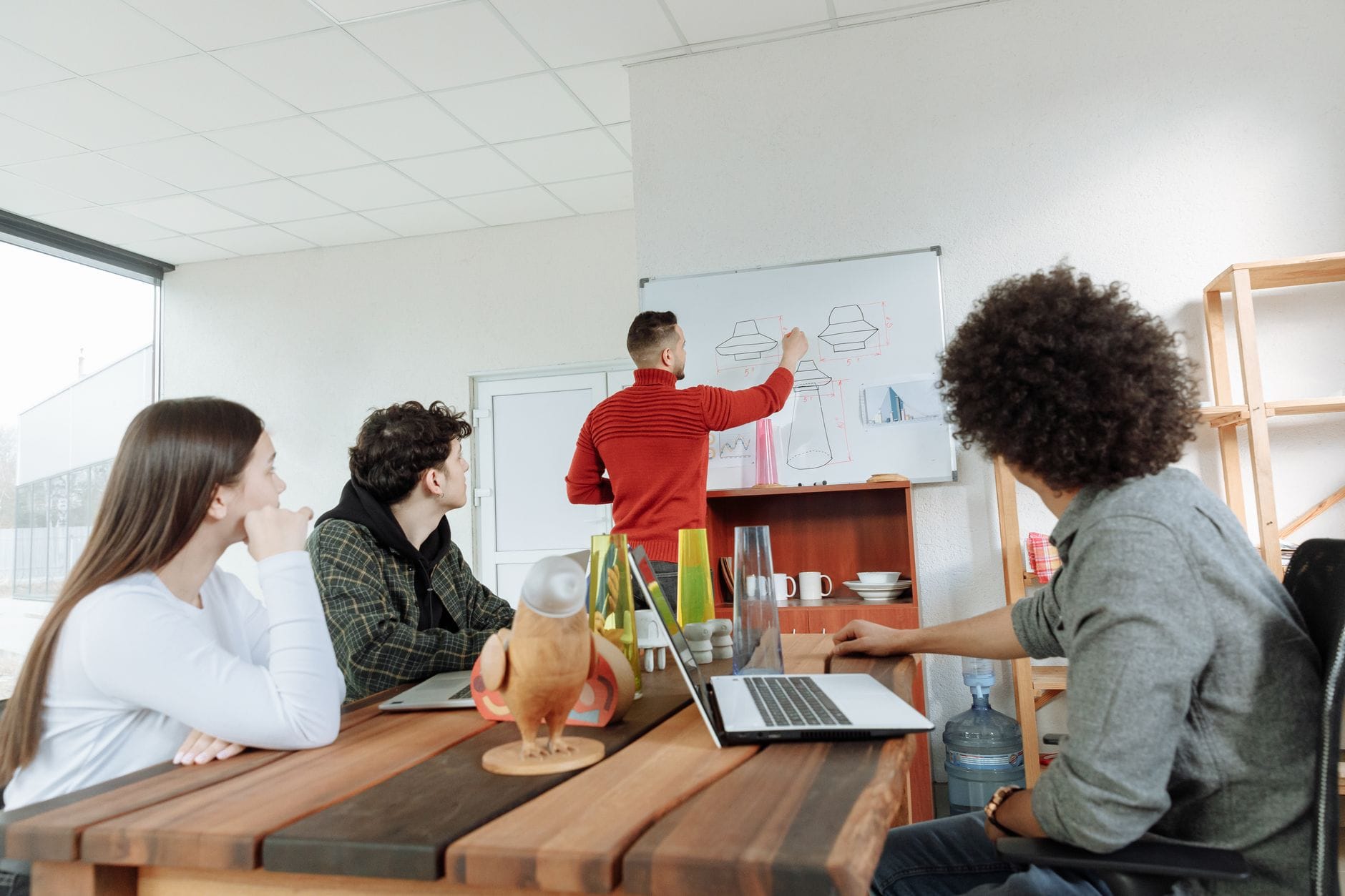 Zespół młodych pracowników omawia projekt w nowoczesnym biurze