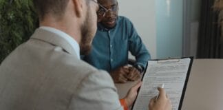 Rekruter przegląda dokumenty kandydata podczas rozmowy kwalifikacyjnej